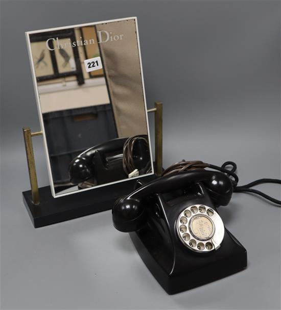 A Christian Dior advertising mirror and a black bakelite telephone